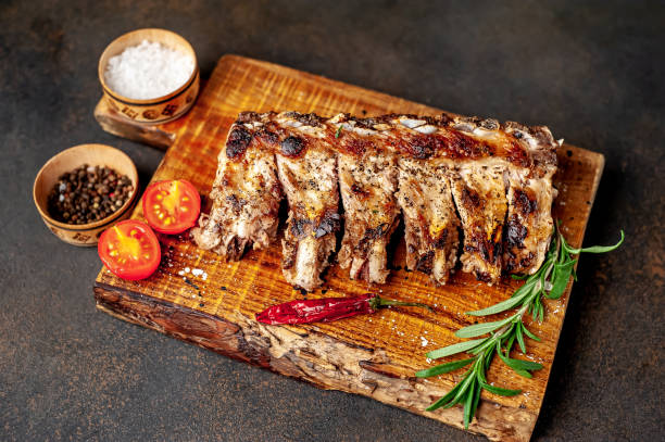 istock Grilled pork ribs with spices on a cutting board on a stone background 1310788500