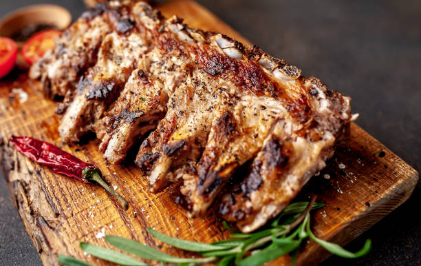 istock Grilled pork ribs with spices on a cutting board on a stone background 1310788516