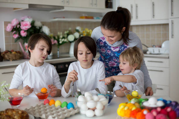 Children, boy siblings, coloring eggs for Easter Children, boy siblings, coloring eggs for Easter at home easter egg coloring stock pictures, royalty-free photos & images