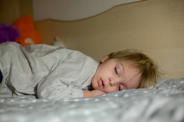 istock Toddler sleeping at home at night, hugging little toy 1310789708