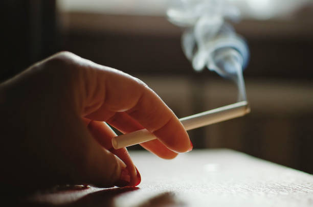 istock Hand holds a smoking cigarette. Smoking harm concept. 1310790795