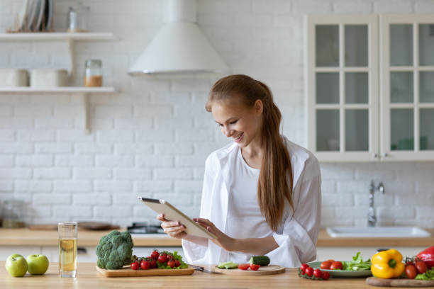 istock Young woman using a tablet computer to cook in her kitchen at home. 1310791001