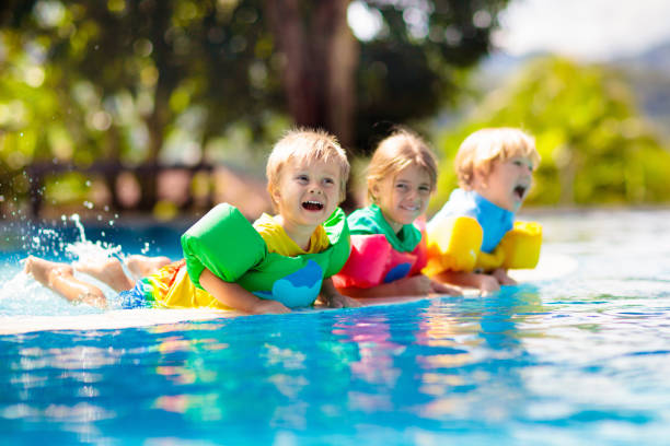 istock Kids in swimming pool. Life jacket for child. 1310791012