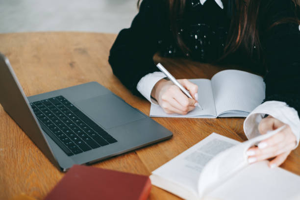 istock Young woman college student taking notes, studying with laptop in library. 1310792084