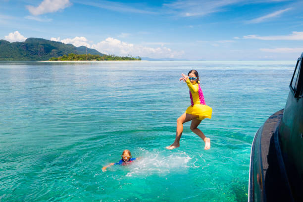 niño saltando al agua del mar. vacaciones en yates. - clear sky water sports and fitness yacht fotografías e imágenes de stock