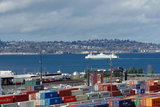여객선은 시애틀과 베인브리지 섬 사이에 흐린 날에 푸젯 사운드를 가로질러 지나가며 지나고 있습니다. 컨테이너 터미널에서 보기. - passenger ship ferry crane harbor 뉴스 사진 이미지