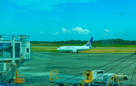 Panama City International Airport, Panama - 08 February, 2015: A Copa Airlines Boeing 737-700 is seen taxiing to take off at Panama City Airport. In the background is the actual airport runway. To the left is the airbridge that was used to board the airplane in Panama in Central America.