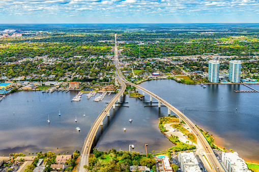 The dual bridge crossing the Halifax River from the coast of Daytona Beach, Florida and merging into one main city street on the far side shot from an altitude of about 1000 feet.
