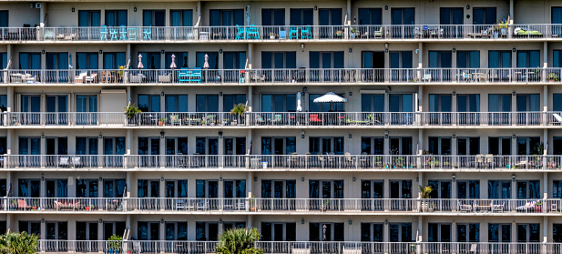 Full frame view of rows of windows and doors of a high rise coastal condominium building along Florida's gulf coast in the town of Destin.