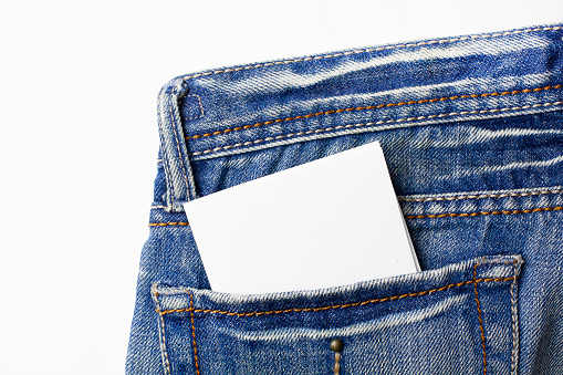 Closeup of a sheet of blank paper with space for text in a pocket of jeans.