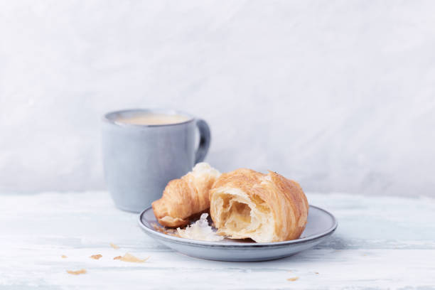 istock Croissant with coffee on bright wooden background. Close up. Copy space. 1310799459