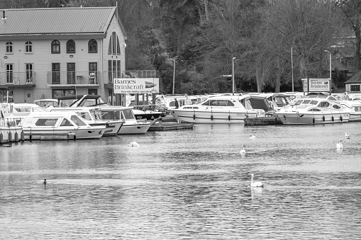 Wroxham, Norfolk, UK - April 02 2021. Black and white image of a view down the River Bure in Wroxham, Norfolk Broads