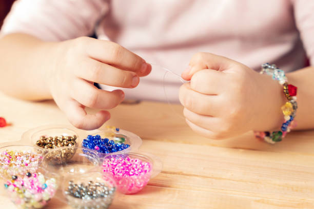istock The child makes jewelry with his own hands, stringing colorful beads on a thread 1310801624