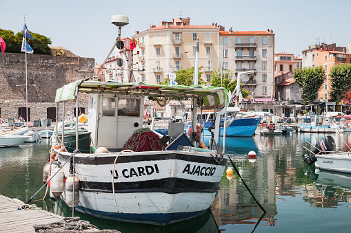 Ajaccio, France - July 6, 2015: Coastal cityscape with sailing yachts and fishing boats moored in marina of Ajaccio, Corsica