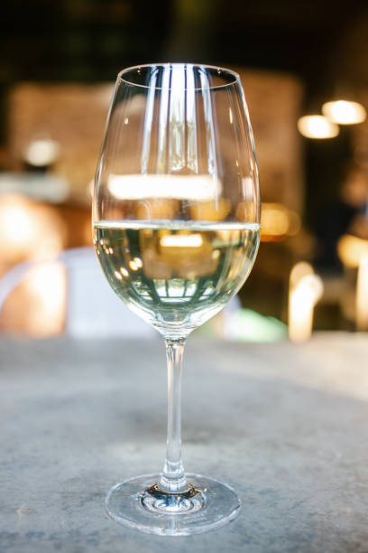 istock Glass of white wine in restaurant setting. 1310809862