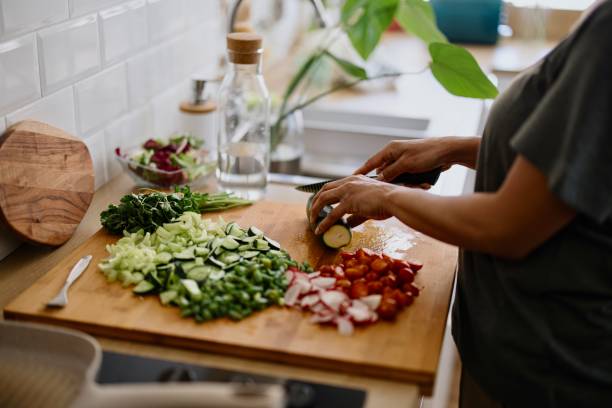 istock Woman cutting zucchini on chopping board 1310811742