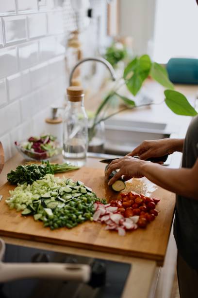 istock Woman cutting zucchini on chopping board 1310812283