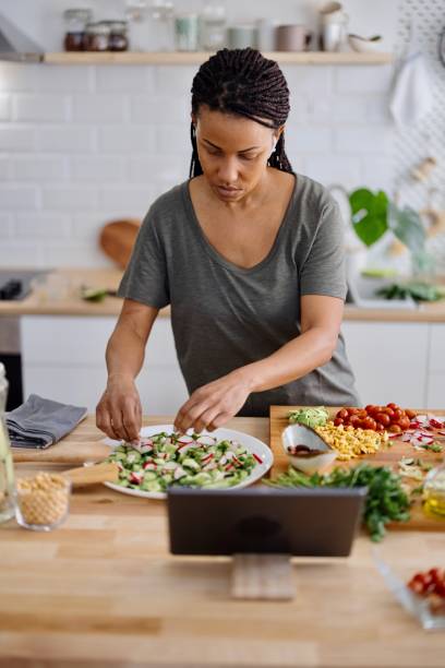 istock Woman arranging veggie salad in the kitchen 1310812310