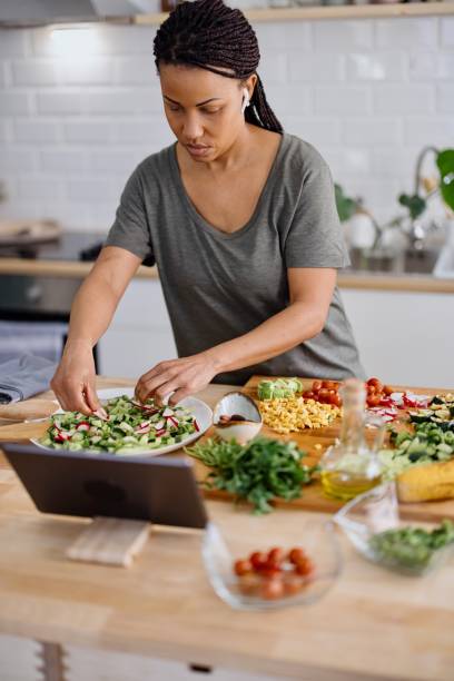 istock Woman arranging veggie salad in the kitchen 1310812348