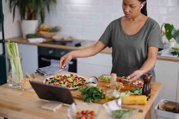 istock Woman arranging veggie salad in the kitchen 1310812365