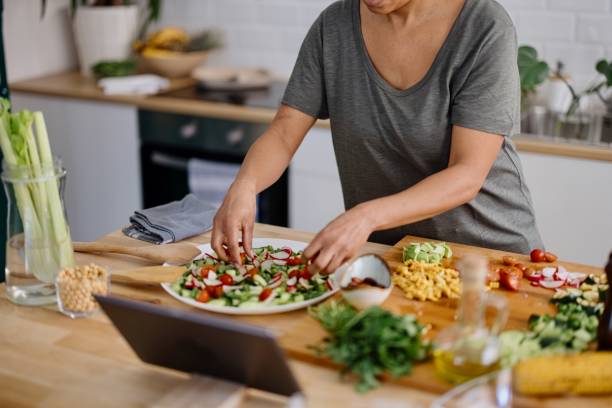 istock Woman arranging veggie salad in the kitchen 1310812367