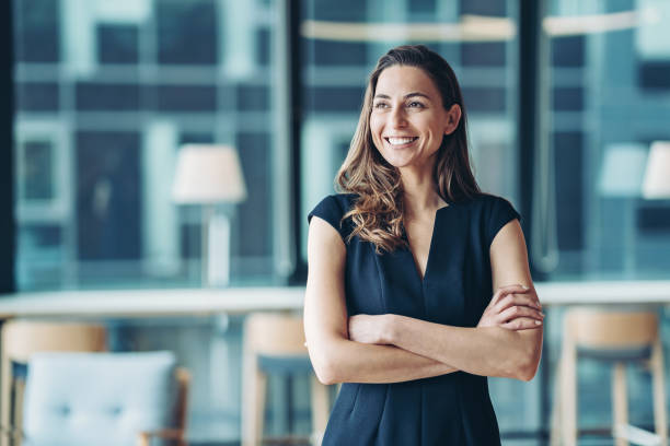 ritratto di un'imprenditrice in piedi in un ufficio moderno - smiling portrait women female foto e immagini stock