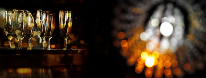 drinking glass in bar at night with golden orange lamp light banner background