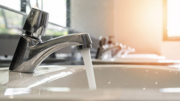 Tap water running wastage from faucet over hand washing sink, ceramic basin in water closet, public wc room or school bathroom for saving ecological and environmental conservation awareness concept agua del grifo que corre el desperdicio del grifo sobre el lavabo de lavado de manos, lavabo de cerámica en el armario de agua, sala de wc pública o baño escolar para salvar el concepto de concienciación sobre la conservación ecológica y ambiental