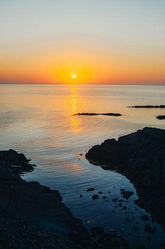 Beautiful sunrise over the sea near a rocky sea coast.
