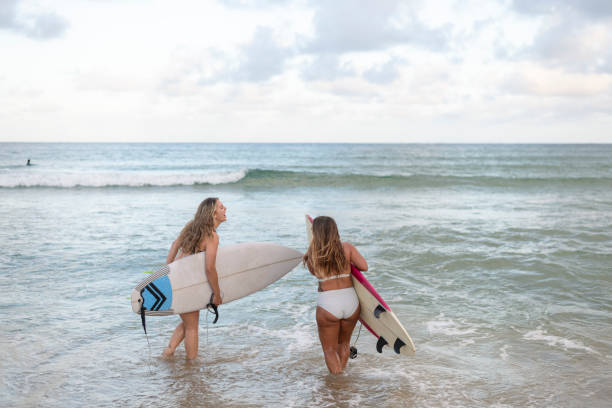 istock Happy friends going surfing 1310819987