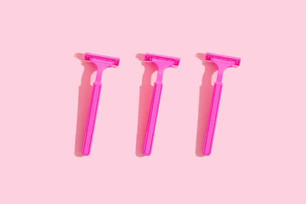 istock Minimal concept: three raspberry-colored ladies' razors with hard shades on a pink background 1310826797