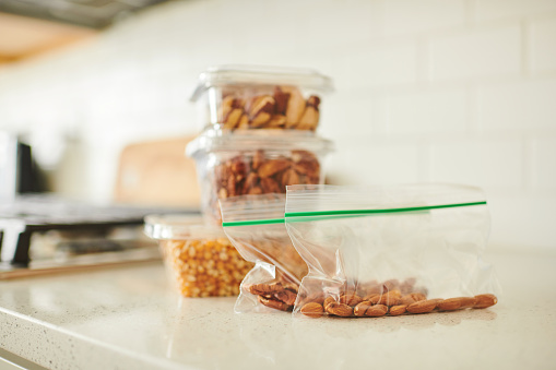 Assorted nuts in plastic containers on a counter in a bright modern kitchen