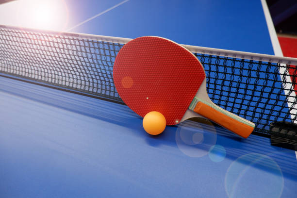 istock on the tennis table is a ball and two table tennis rackets. 1310833151