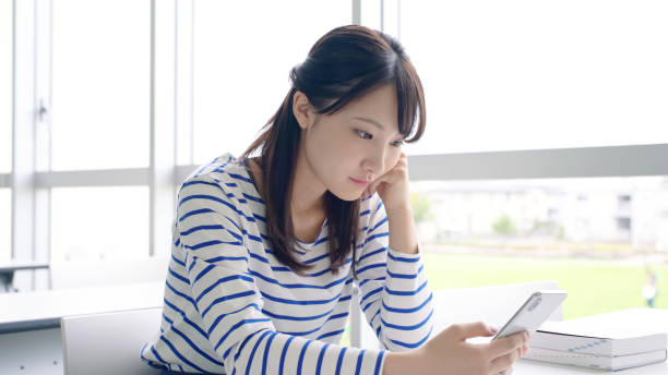istock Young asian female student using a smart phone. 1310834725
