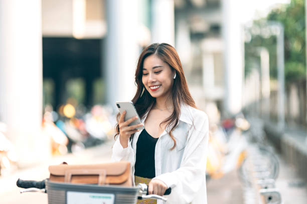 istock young woman using her cellphone while out cycling through the city 1310839609