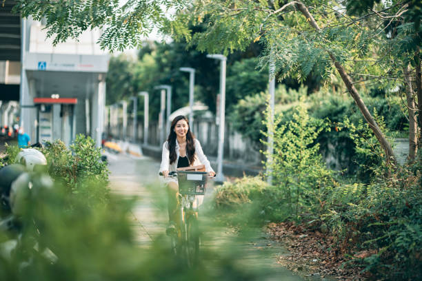 jovem asiática andando de bicicleta ao ar livre - environmental conservation audio - fotografias e filmes do acervo