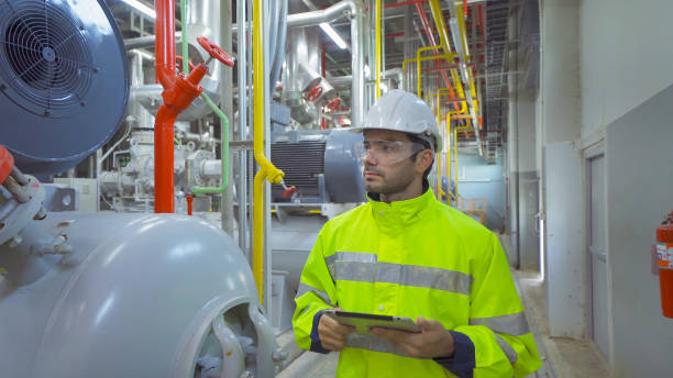 istock An engineer man or worker, people using a tablet device, working in industry factory. Chiller tower or cooling tower in building. System work machine. Condenser Water Supply pipe lines. Ventilation. 1310844507
