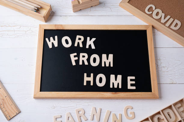 istock `Work from Home` words on a modern board on a white wooden surface, top view. Overhead, from above, flat lay. 1310846143