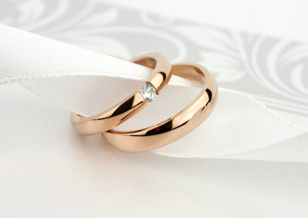 istock Two golden wedding rings with diamond on grey background 1310848133