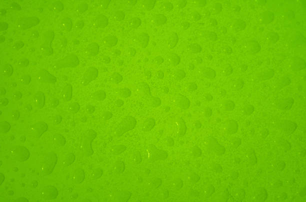 Vivid green colored water droplets on the tabletop top view