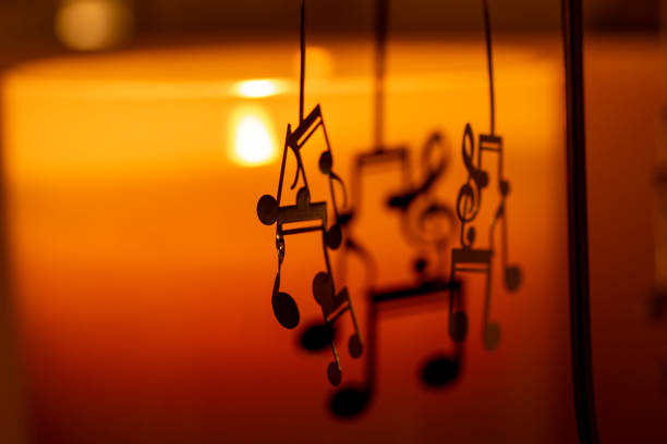 istock Close-up abstract view of a spinning mobile with musical notes illuminated by candlelight 1310850434