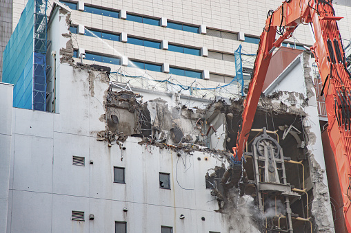 Demolition site in Tokyo with a crane working and using water to avoid all the dust spreading in the air