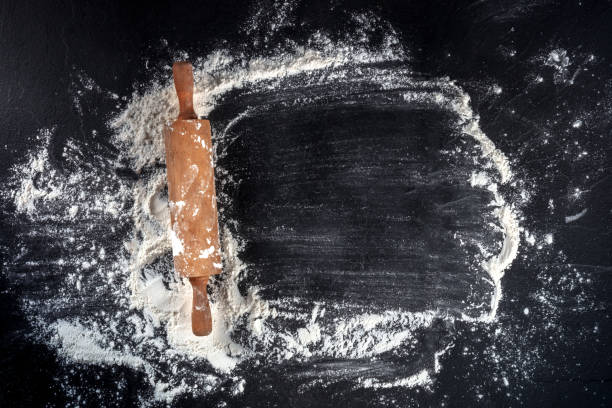 Baking background with white flour and a rolling pin, overhead shot Baking background with white flour and a rolling pin, overhead shot with a place for text flour mess stock pictures, royalty-free photos & images