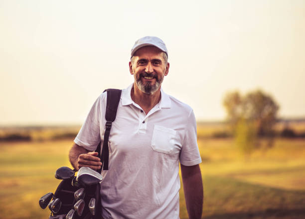 retrato del hombre mayor. golfista senior caminando en la cancha de golf con bolsa. - retirement golfer happiness relaxation fotografías e imágenes de stock