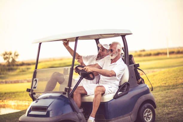 istock Two older friends are riding in a golf cart. 1310852717