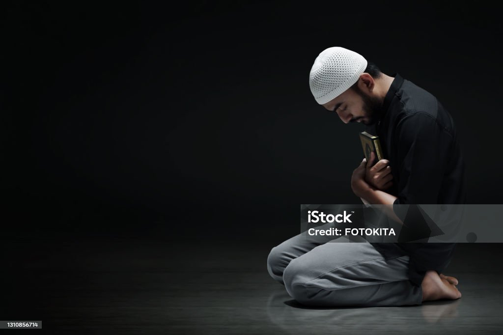 Religious asian muslim man holding holy quran Islam Stock Photo