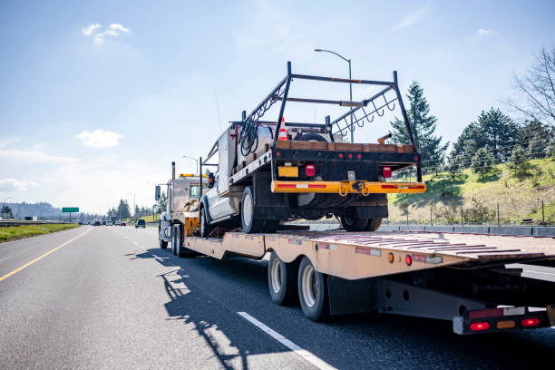 istock Powerful big rig semi truck transporting another truck on step down semi trailer driving on the wide straight highway road 1310856968