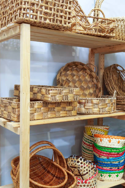 istock Eco-friendly goods, home space organization and storage, various natural straw wicker baskets stand on a shelf on a wooden rack in a shop window on sale 1310857996