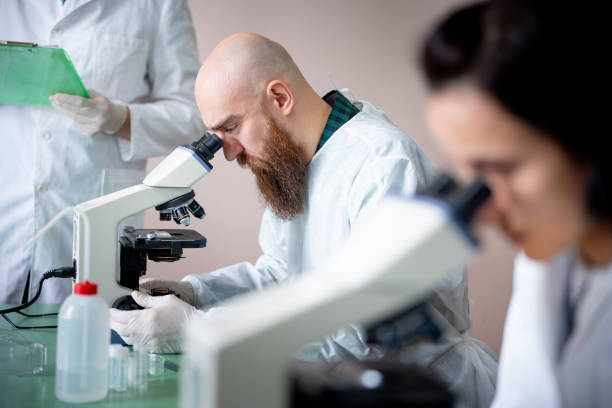 istock Scientist and colleagues focused on doing research  in microscopy lab 1310859532