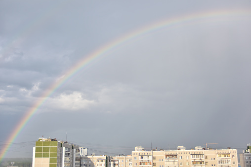 29-07-2020, Yekaterinburg, Russia: bright rainbow over the city buildings, the view from the top floor at the living area of Botanickesky town